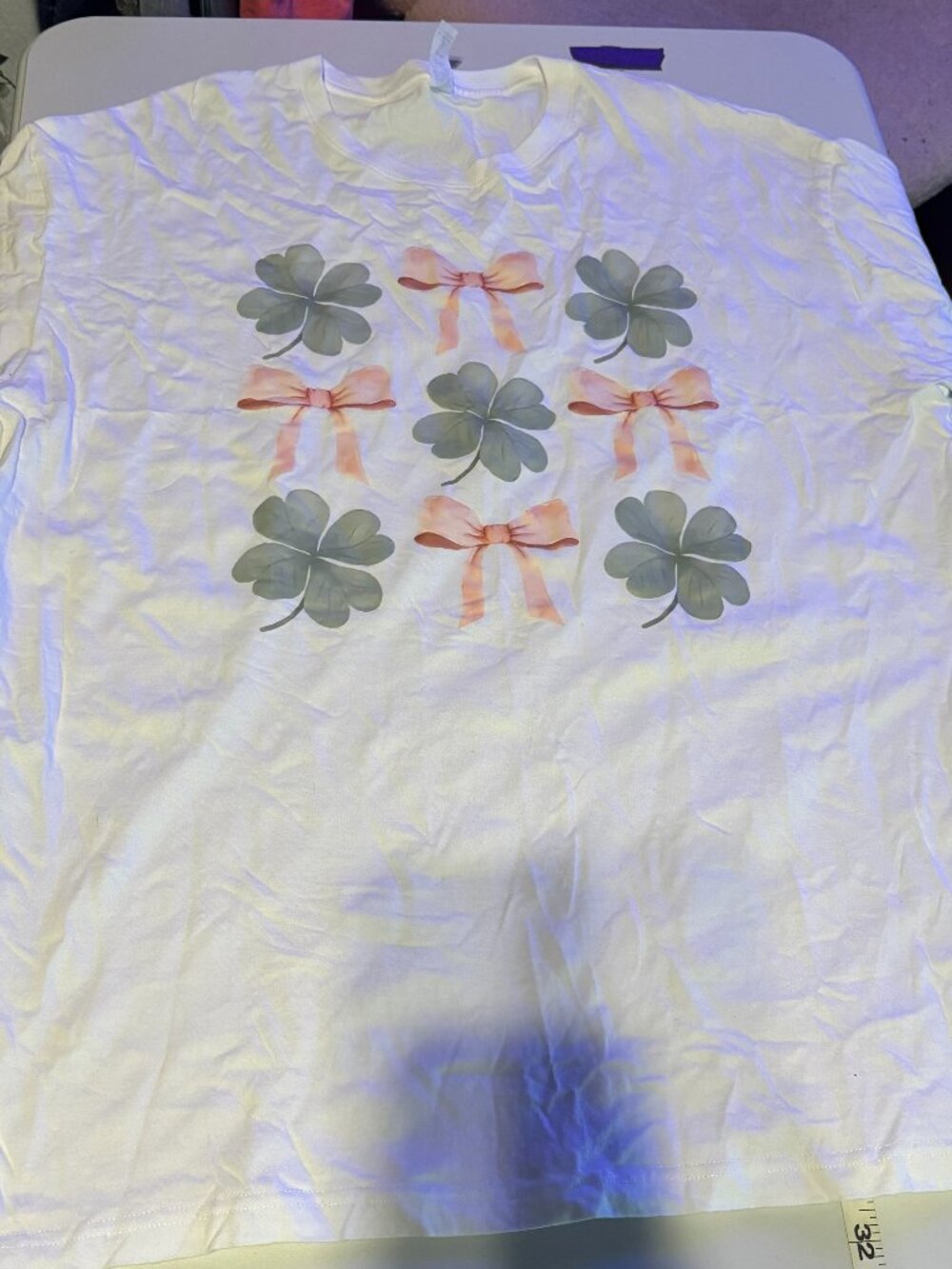 "Black short-sleeve V-neck tee. Front print of three green shamrock gnomes. Cute